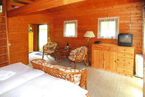 a bedroom with a bed and a tv in a cabin at Blockhouses at Fährsee, Templin in Templin