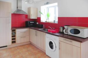a kitchen with a washing machine and a microwave at Cottage in Brittany with Stunning Sea Views in Telgruc-sur-Mer