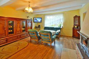 sala de estar con mesa, sillas y TV en holiday home, Spore en Szczecinek