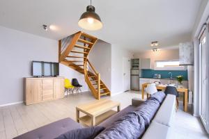 a living room and kitchen with a couch and a staircase at Apartment in Rogowo near Baltic Sea Beach in Rogowo