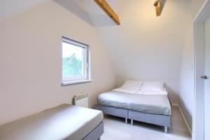 two beds in a small room with a window at Apartment in Rogowo near Baltic Sea Beach in Rogowo +13 photos