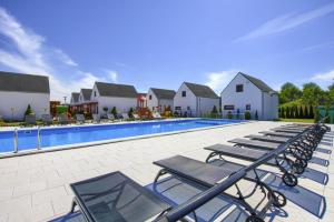 a row of lounge chairs next to a swimming pool at Apartment in Rogowo near Baltic Sea Beach in Rogowo