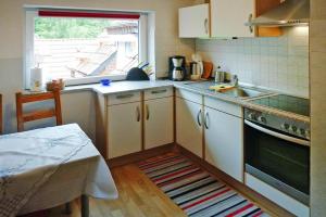 una pequeña cocina con fregadero y ventana en Holiday Apartment An der Meiße, Bergen, en Bleckmar