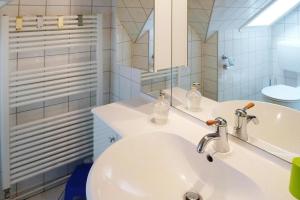Baño blanco con lavabo y espejo en Holiday Apartment An der Meiße, Bergen, en Bleckmar