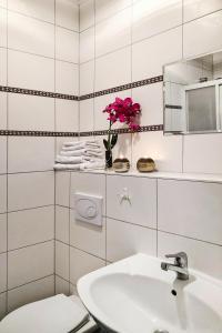 a bathroom with a sink and a toilet and a vase of flowers at Schönes Ferienhaus mit Terrasse in Sommersdorf