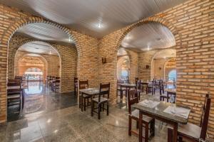 a restaurant with brick walls and tables and chairs at Coliseum Beach Hotel All Inclusive in Beberibe