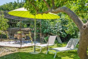 卡斯蒂廖內迪西奇利亞的住宿－Holiday home, Castiglione di Sicilia，树下的一个黄伞和两把椅子