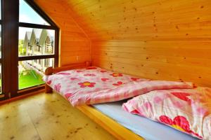a bed in a wooden room with a window at Holiday resort, Grzybowo in Grzybowo