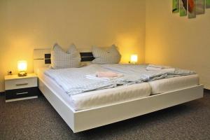 a bedroom with a large bed with two lamps on it at Ferienhaus Vieting direkt am Eldeufer in Parchim in Parchim