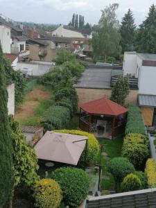 Blick auf einen Garten mit einem Gebäude und einem Sonnenschirm in der Unterkunft Ferienwohnung Andreea in Saarlouis