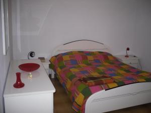 フォンターネ・ビアンケにあるVilla Dolci Vacanzeのベッドルーム1室(ベッド1台、テーブルの上に赤いボウル付)