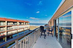 a balcony with chairs and a table on the beach at Surfcaster Unit 401 in Ocean City