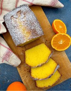 a wooden cutting board with three pieces of bread and oranges at Le Ghiande in Spello