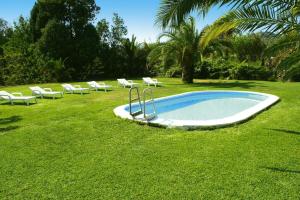 a pool with white chairs and a bunch ofitures at Holiday home, Castiglione di Sicilia in Castiglione di Sicilia