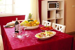 a red table with fruits and vegetables in bowls on it at Holiday home, Castiglione di Sicilia in Castiglione di Sicilia