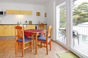 een keuken met een tafel en stoelen en een balkon bij Apartment house, Zinnowitz in Zinnowitz