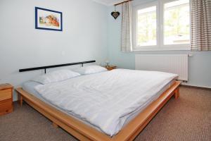 een slaapkamer met een groot wit bed en een raam bij Apartment house, Zinnowitz in Zinnowitz