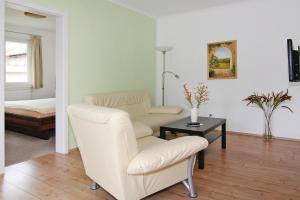 een woonkamer met een bank, een stoel en een tafel bij Apartment house, Zinnowitz in Zinnowitz