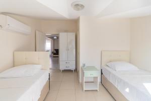Habitación blanca con 2 camas y espejo. en Apartments Near to City Center and Beach, en Marmaris