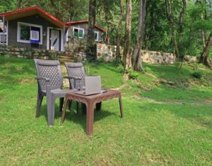two chairs and a table with a laptop on it at Bird Retreat by StayApart, Rishikesh in Rishīkesh