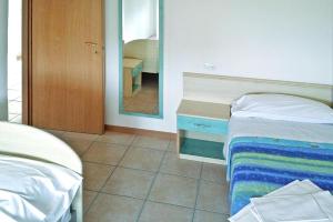 a bedroom with two beds and a mirror at Residence Solaria, Lido Adriano in Lido Adriano