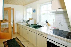 a kitchen with a sink and a stove top oven at Apartments Jeske Altenkirchen in Altenkirchen