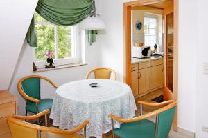 una mesa y sillas en una cocina con mesa y ventana en Apartments Jeske Altenkirchen, en Altenkirchen