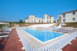 basen z krzesłami i budynkiem w tle w obiekcie Apartment in Pedaso with Sea View & Pool w mieście Pedaso