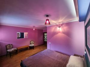 Schlafzimmer mit lila Wänden, einem Bett und einem Tisch in der Unterkunft Hrachy Mot - Gyumri in Gjumri