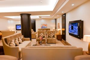 uma sala de estar com sofás e uma televisão de ecrã plano em The Artisan Hotel-Suits em Jeddah