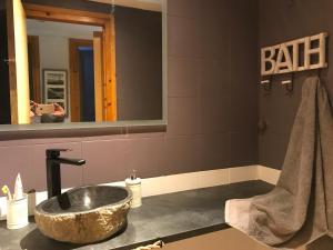 a bathroom with a stone sink and a mirror at Apartament el Cérvol in La Molina