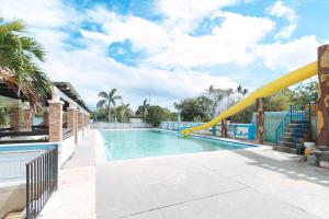 a swimming pool with a slide at a resort at Reddoorz @ Royal Grande Beach Resort Batangas in Batangas City