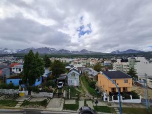 une ville avec des maisons et des montagnes en arrière-plan dans l'établissement PlaceresCC, à Ushuaia