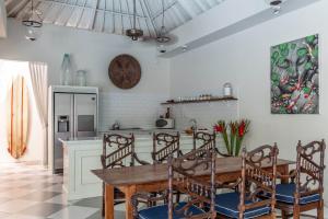 a kitchen with a wooden table and chairs at Villa Seni in Seminyak