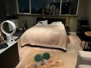 a bedroom with a bed and two potted plants on the floor at Studio Casa Martine in Noordwijk aan Zee