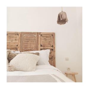 1 dormitorio con 1 cama con cabecero de madera en Villa Nour, en Essaouira