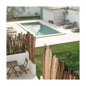 un patio trasero con piscina y valla de madera en Villa Nour, en Essaouira