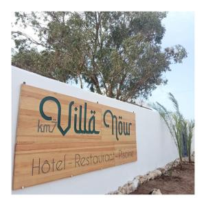 un letrero para un hotel resort en una pared blanca en Villa Nour, en Essaouira
