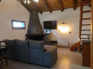 sala de estar con sofá y chimenea en Magic Borda Puntal HUT 7983, en Ordino