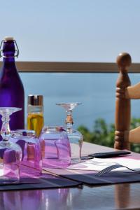 a table with glasses and bottles on a table at Hotel Alata in Alata