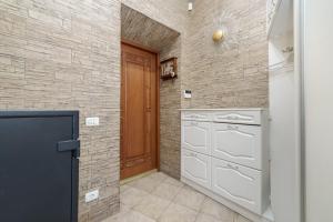 a kitchen with white appliances and a brick wall at Katerynyska 2 Level Apartment with Sauna in Odesa