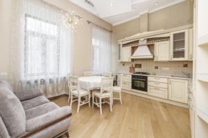 a kitchen with a table and chairs and a couch at Katerynyska 2 Level Apartment with Sauna in Odesa