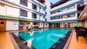 uma grande piscina num edifício com cadeiras em La-Paz Gardens Beacon Hotel - Vasco da Gama Goa em Vasco da Gama