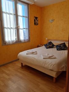 ein Schlafzimmer mit einem Bett und einem großen Fenster in der Unterkunft Auberge le Cheylet in Apchon