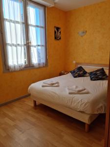 a bedroom with a bed and a large window at Auberge le Cheylet in Apchon