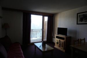 un salon avec une grande fenêtre et une télévision dans l'établissement Résidence Cristallines - 2 pièces 4 personnes MAE-4434, à Orcières 7 autres photos