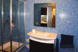 a blue tiled bathroom with a sink and a shower at holiday home, Vale de Cambra - Rôge in Vale de Cambra