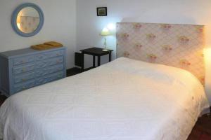 Schlafzimmer mit einem weißen Bett, einer Kommode und einem Spiegel in der Unterkunft holiday home, Folhada in Marco de Canavezes