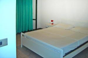- une chambre avec un lit blanc et un rideau vert dans l'établissement Apartment in Silvi Marina with parking space, à Silvi Marina
