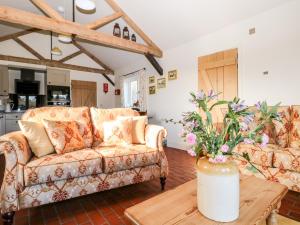 a living room with a couch and a table at The Cowshed in Battle